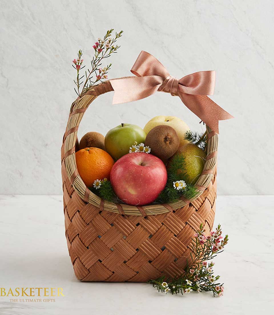 Classic Brown Rattan Gift Basket Filled with a variety of fresh fruits such as green kiwis, oranges, and red apples. and many others Decorated with a shrimp paste colored ribbon bow.
