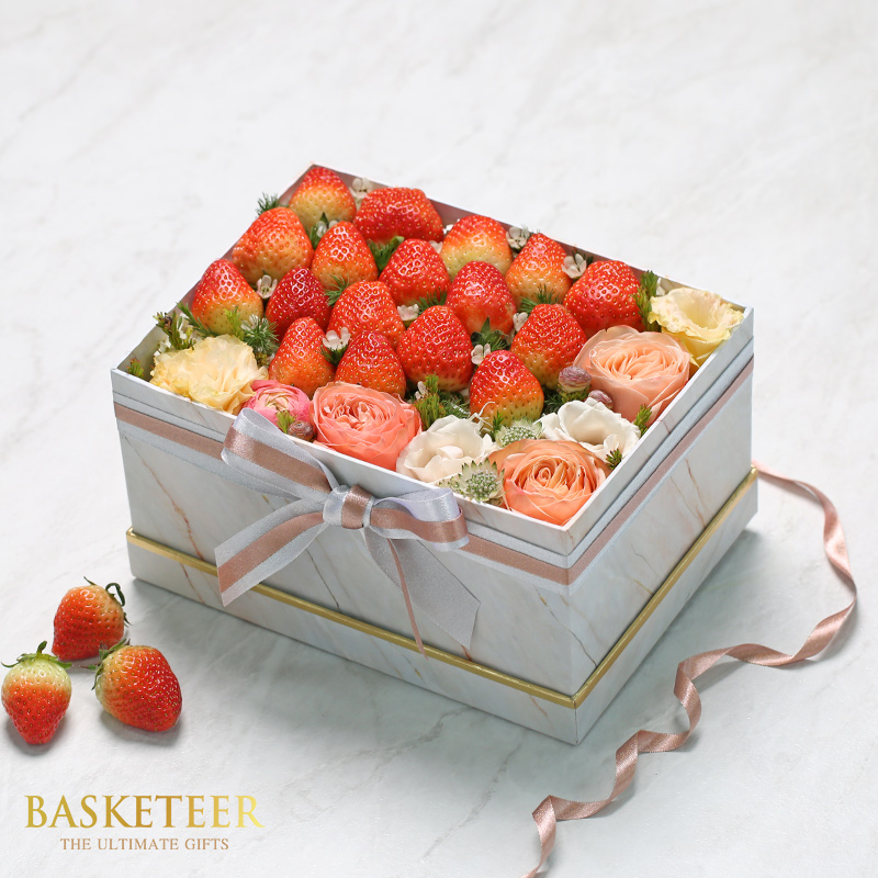 Strawberrys and flowers in a gift box with a bow