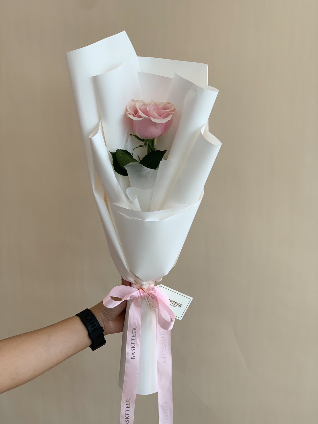 A single pink rose bouquet wrapped in elegant white paper with a pastel pink ribbon, perfect for romantic surprises, proposals, or a heartfelt gift.