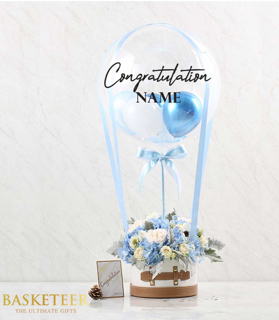 A charming arrangement featuring light blue hydrangea blooms and cheerful balloons, ideal for brightening someone's day!