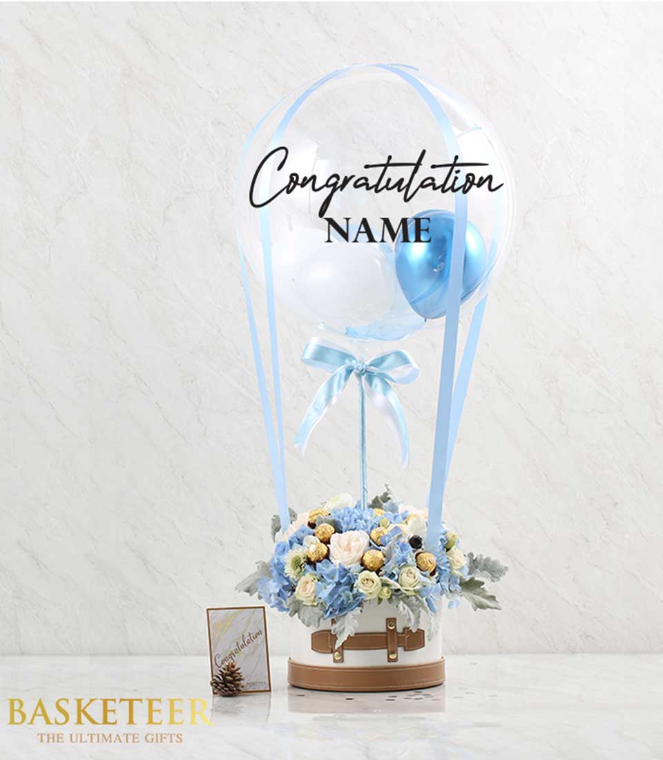 A delightful arrangement featuring blue flowers, decadent chocolates, and cheerful balloons, perfect for spreading joy and sweetness!