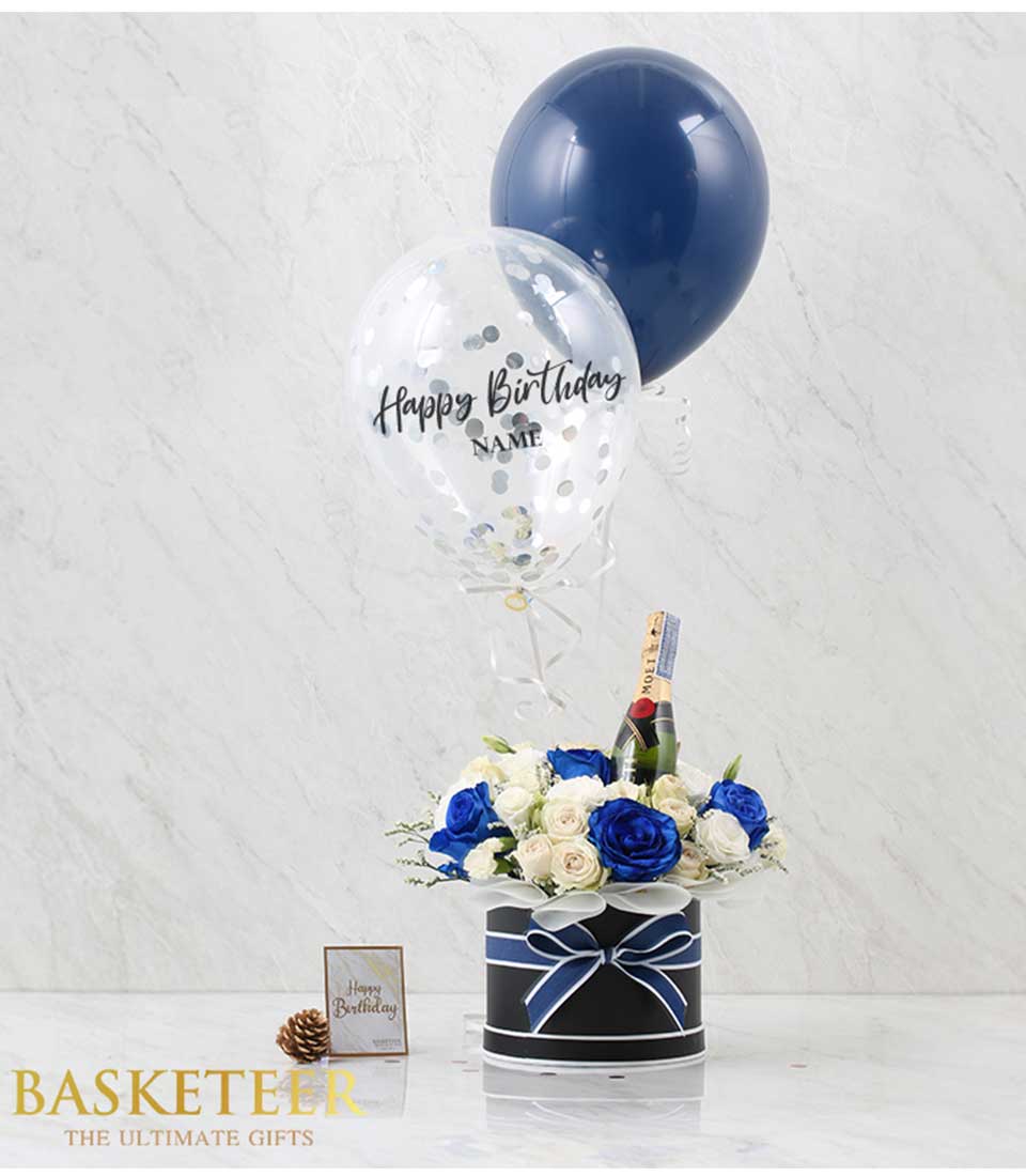 Discover our Flowers Wine Blue Balloon Box Blue Tone Combo Set, featuring an elegant arrangement of flowers in blue tones, accompanied by a bottle of wine and a festive blue balloon.