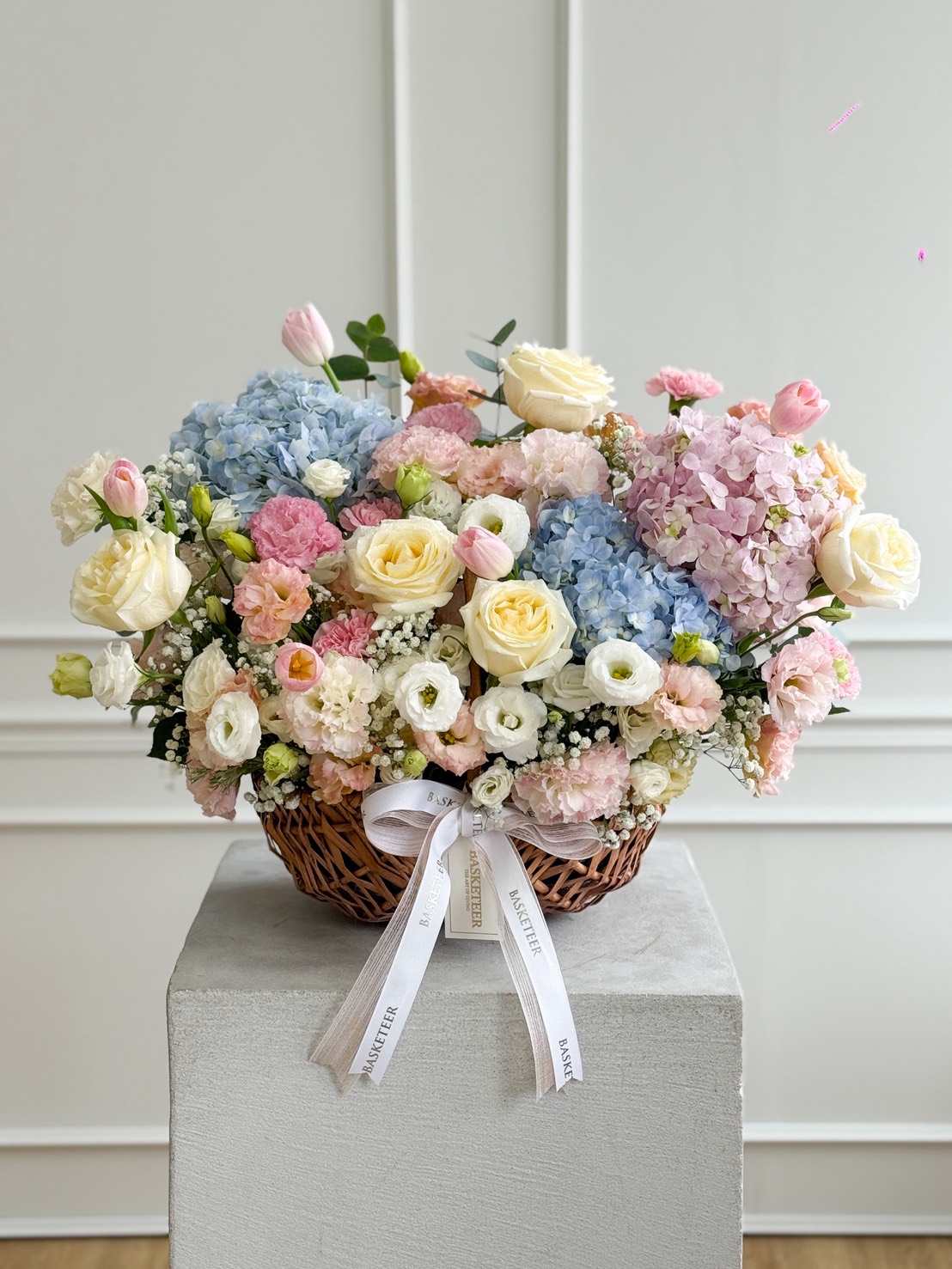 Pastel flower basket arrangement with roses, hydrangeas, lisianthus, and tulips by Flowers by Basketeer — luxury flower delivery in Bangkok.