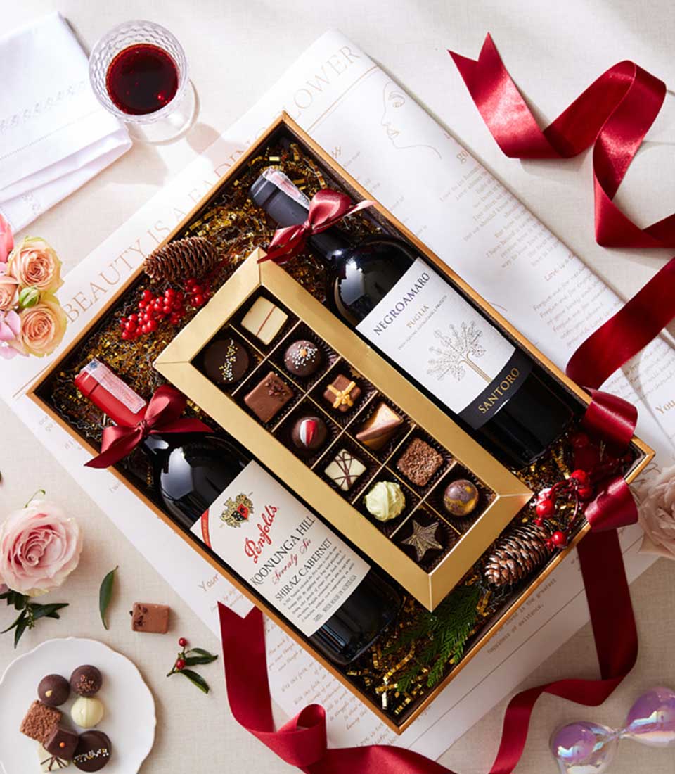 An elegant box set featuring a bottle of fine wine and assorted artisanal chocolates, perfect for indulging in luxury and sophistication.
