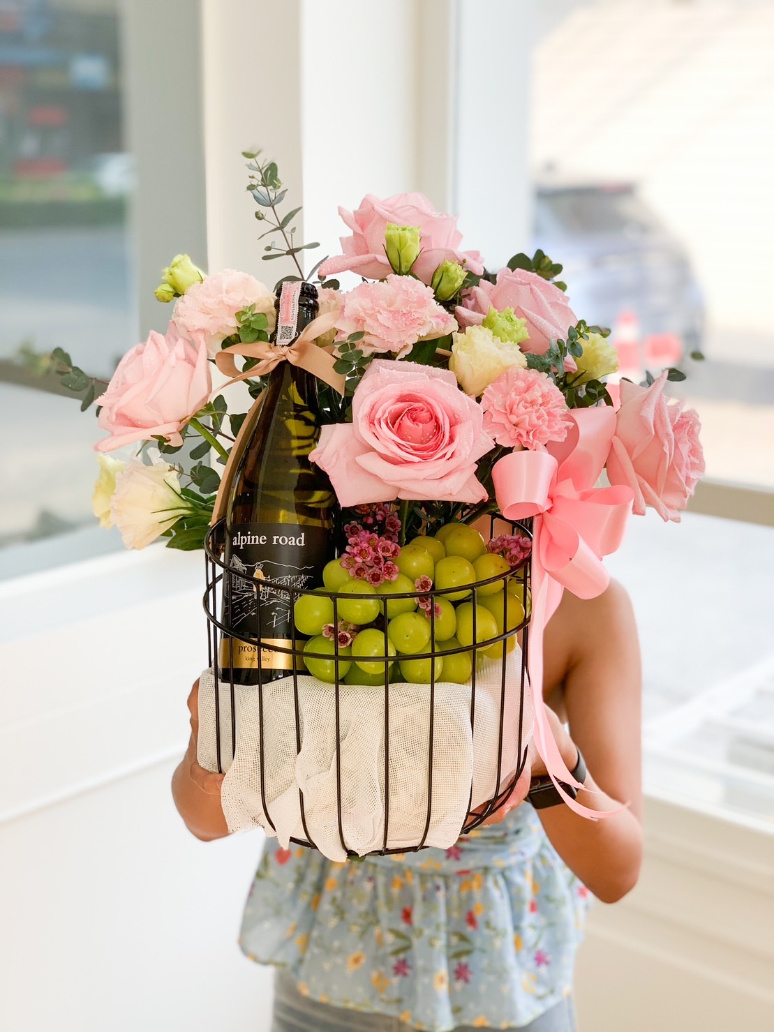 Wine With Green Grape And Sweet Pink Flowers In The Black Steel Frame Basket