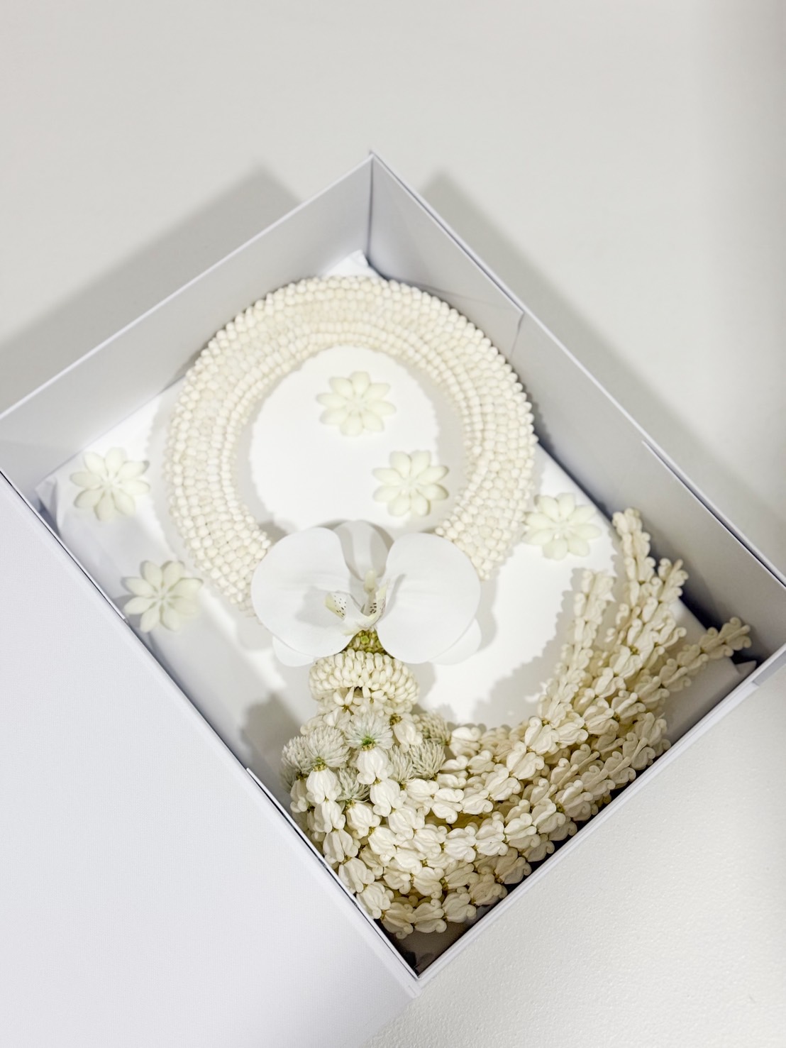 Premium white jasmine garland with white orchid accent, presented in an elegant gift box, angled view – perfect for Mother’s Day.