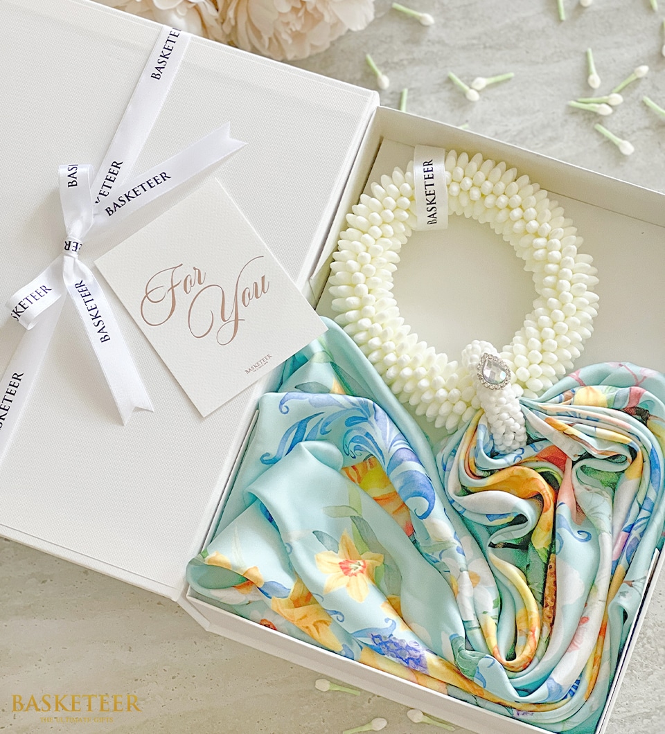 A gift box sits open on a light surface, containing a note labeled 