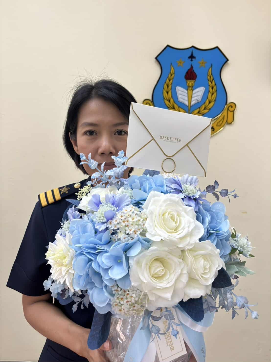 Elegant bouquet of white roses and blue hydrangeas with delicate fillers, decorated with ribbon and message card.