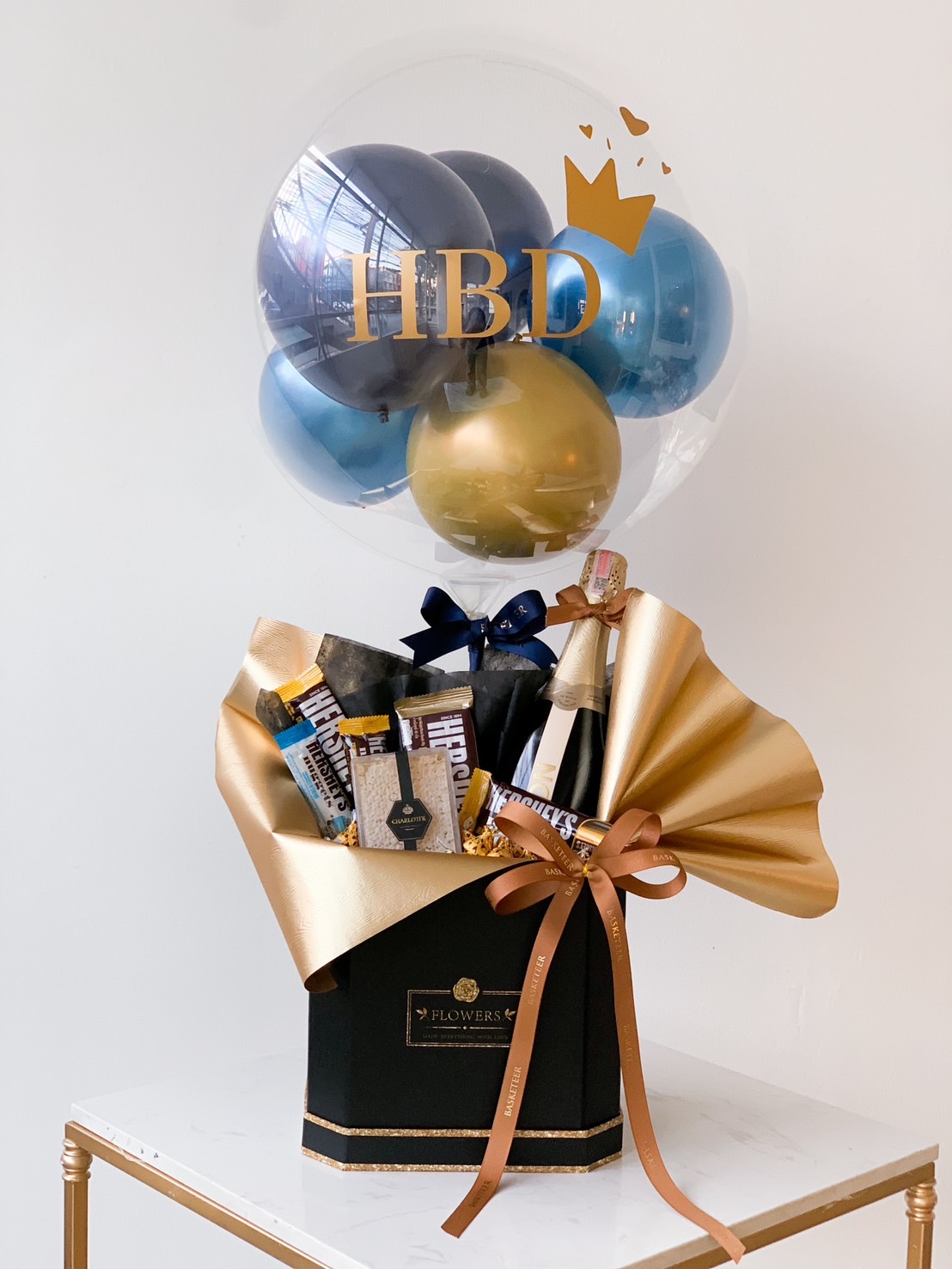 A birthday gift arrangement featuring a clear balloon with 