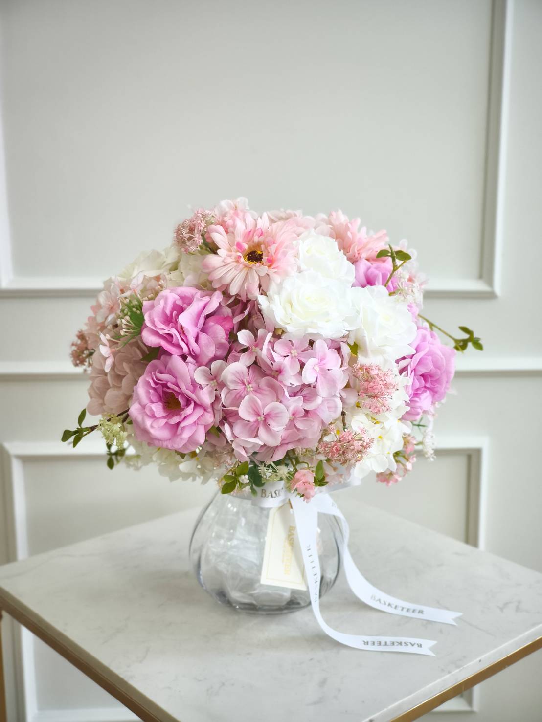 Luxury pink vase arrangement with roses, dahlias, anemones, ranunculus, and pink orchids, styled in a ceramic vase with satin ribbon