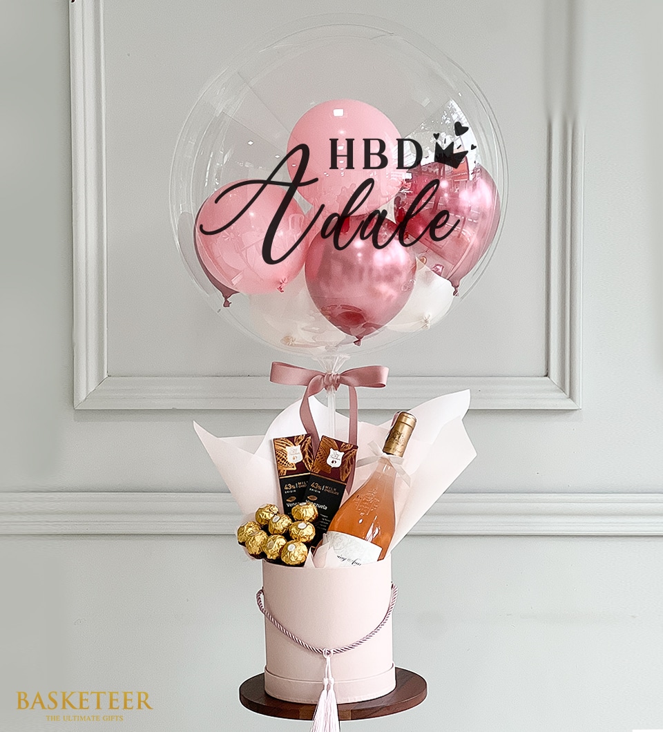 A luxurious birthday gift arrangement showcasing an elegant clear balloon emblazoned with 