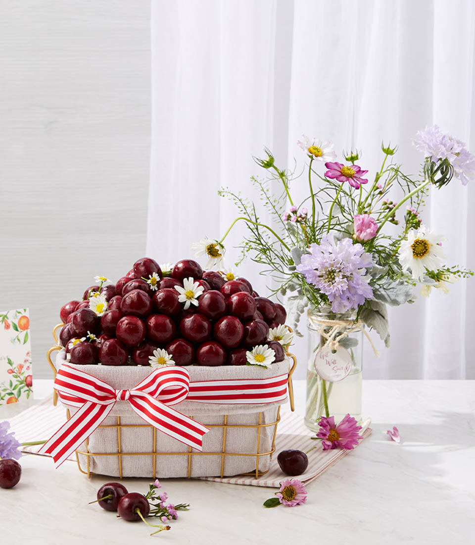 Cherries Fruit In The Golden Steel Frame Basket With A Small Soft Purple Flowers Vase