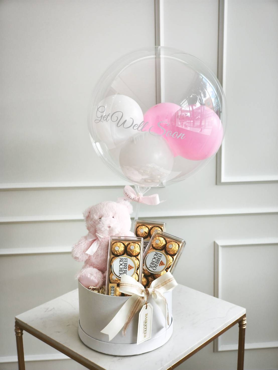 Get well soon gift box with pastel balloon, teddy bear, and Ferrero Rocher chocolates, decorated with ribbon