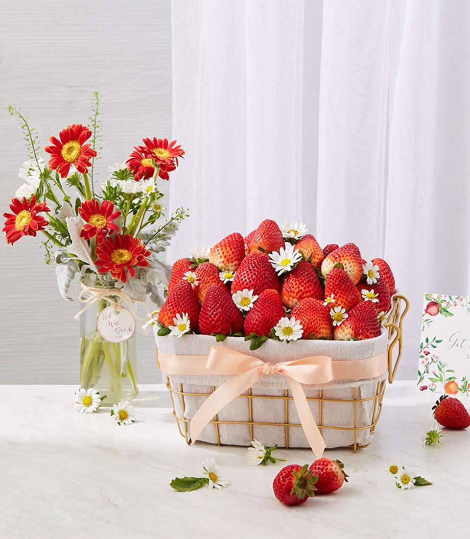 Strawberries In The Golden Steel Frame Basket With A Small Blooming Flowers Vase
