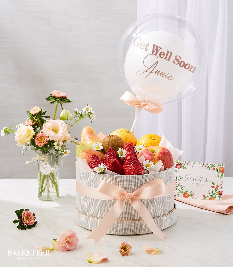 Fresh Fruits And Get Well Soon Balloon With A Small Bright Flowers Vase.