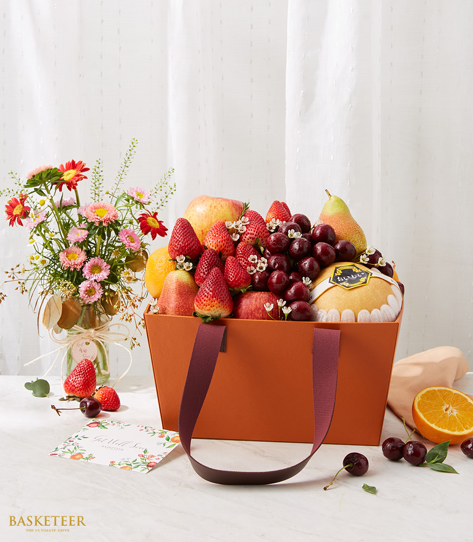 Fresh Fruits In The Brown Bag Box With A Small Blooming Flowers in Vase