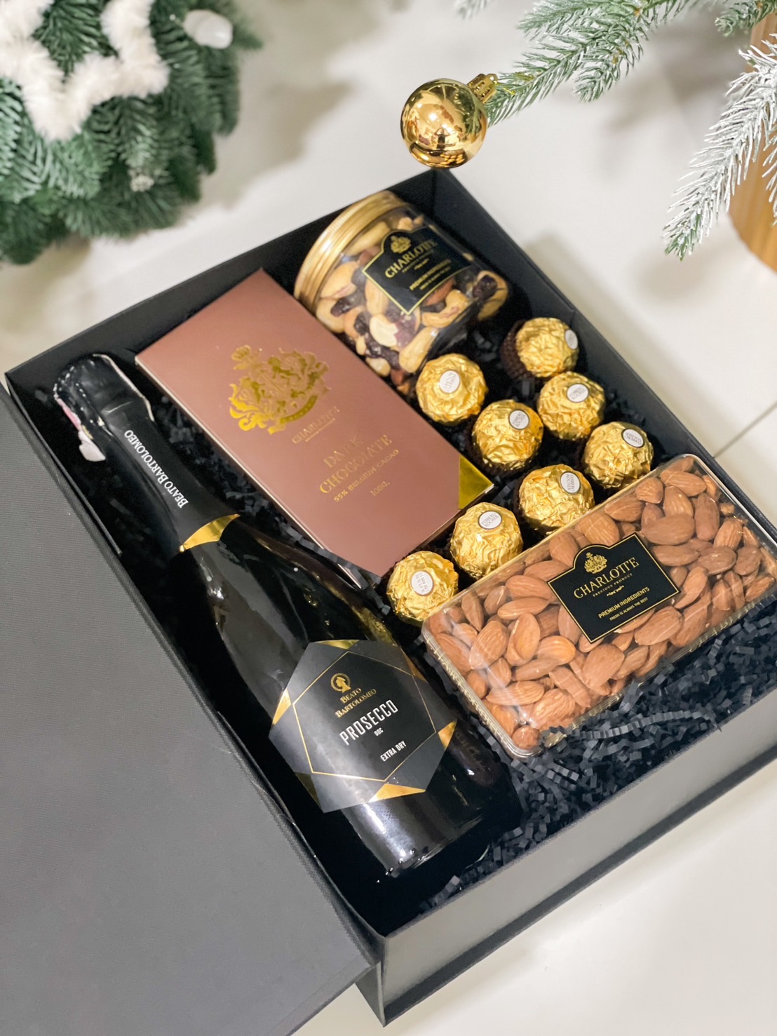 Luxury gift box with Prosecco, dark chocolate, Ferrero Rocher chocolates, roasted almonds, and a jar of mixed nuts.