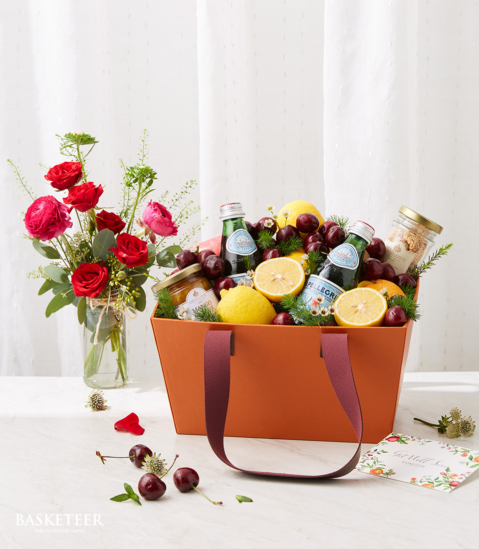 Fresh Fruits And Healthy Drink In The Brown Fashion Box Bag With Red Flowers Vase