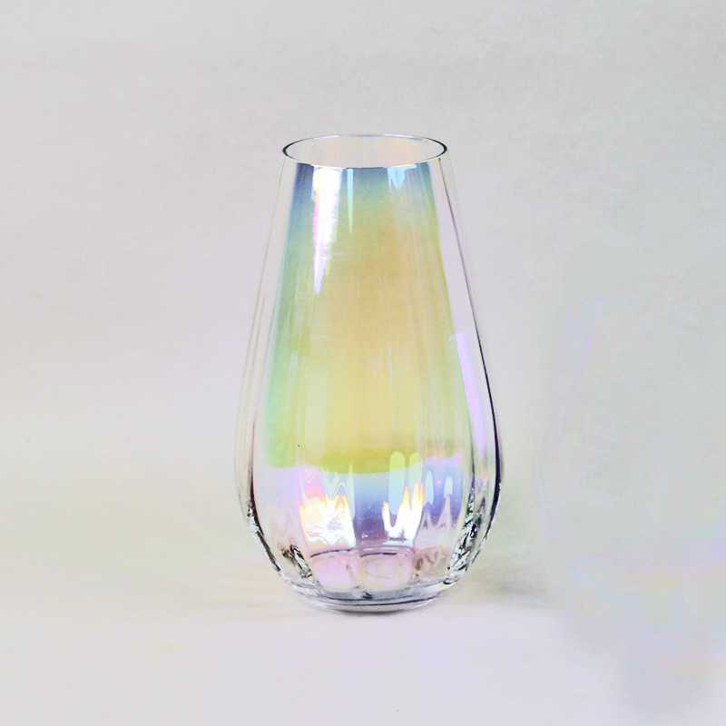 A teardrop-shaped, iridescent glass vase with a luxurious gradient of enchanting colors including sunlit yellow, verdant green, and blush pink. This exquisite vase boasts a flawless, smooth surface and proudly showcases the Basketeer branding on a delicate ribbon tied around its neck. Presented against an immaculate white backdrop, this elegant piece invites admiration and brings opulence to any space it graces.