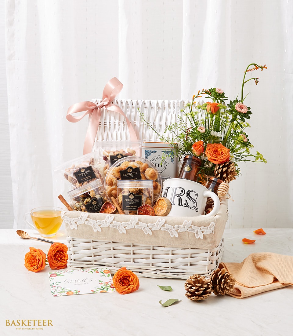 Nuts, Mix Dried Fruits And Tea in The White Hamper With A Small Orange Flowers Vase