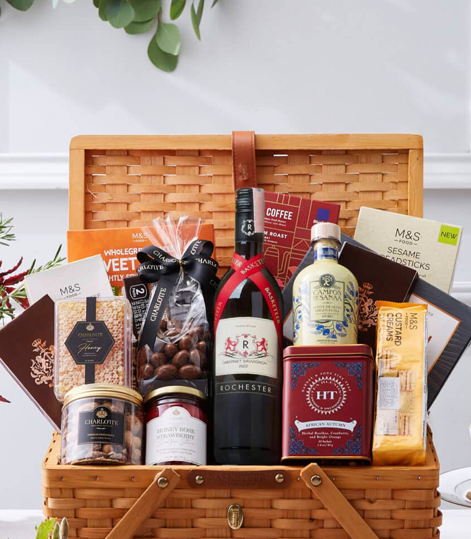 A premium gourmet picnic basket filled with fine wine, artisanal chocolates, gourmet snacks, and luxury tea, beautifully presented in a classic woven picnic hamper.