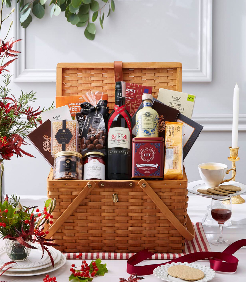A premium gourmet picnic basket filled with fine wine, artisanal chocolates, gourmet snacks, and luxury tea, beautifully presented in a classic woven picnic hamper.
