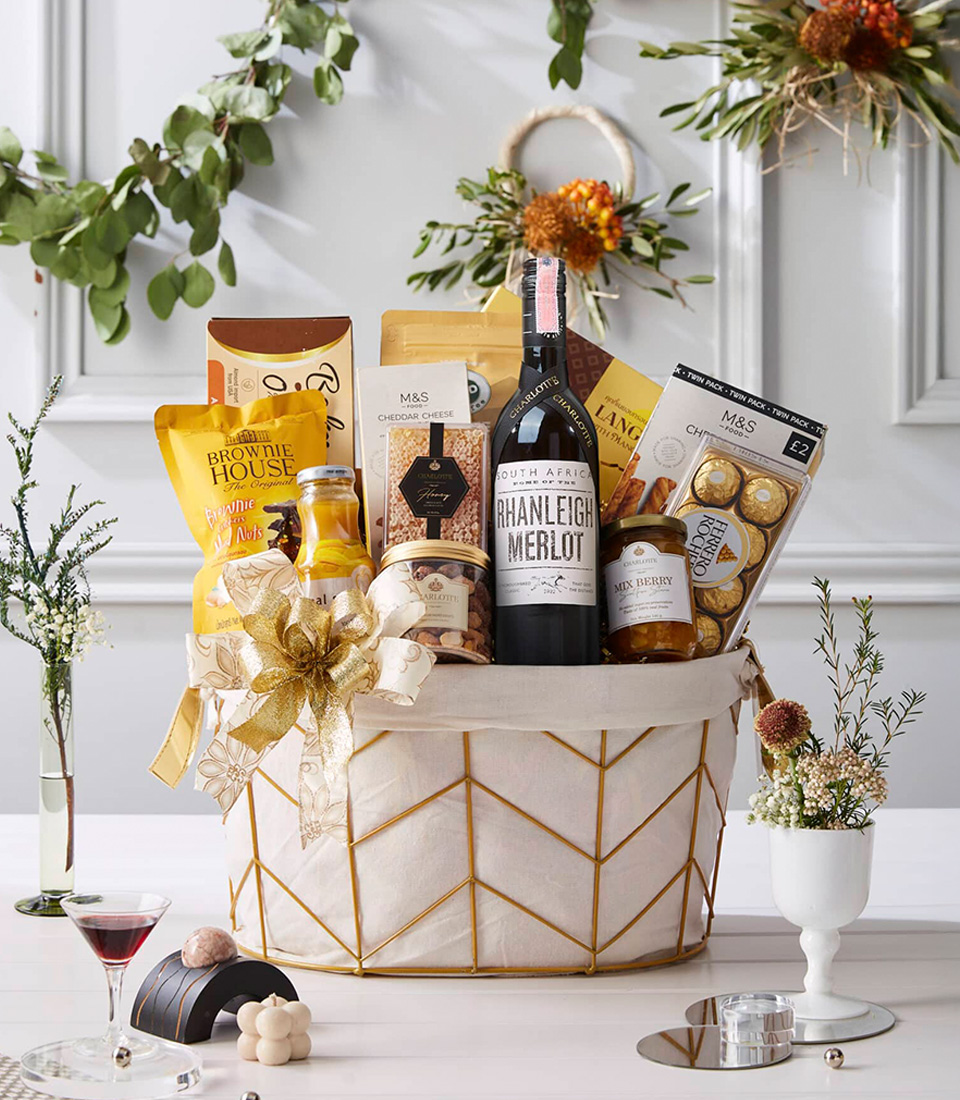 Elegant ivory-gold basket with South African Merlot wine, chocolates, honey, biscuits, nuts, juice, and gold ribbon