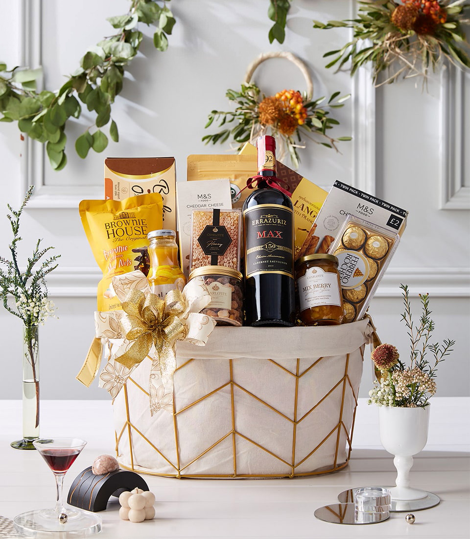 Elegant ivory-gold basket with Cabernet Sauvignon red wine, chocolates, honey, biscuits, nuts, juice, and gold ribbon