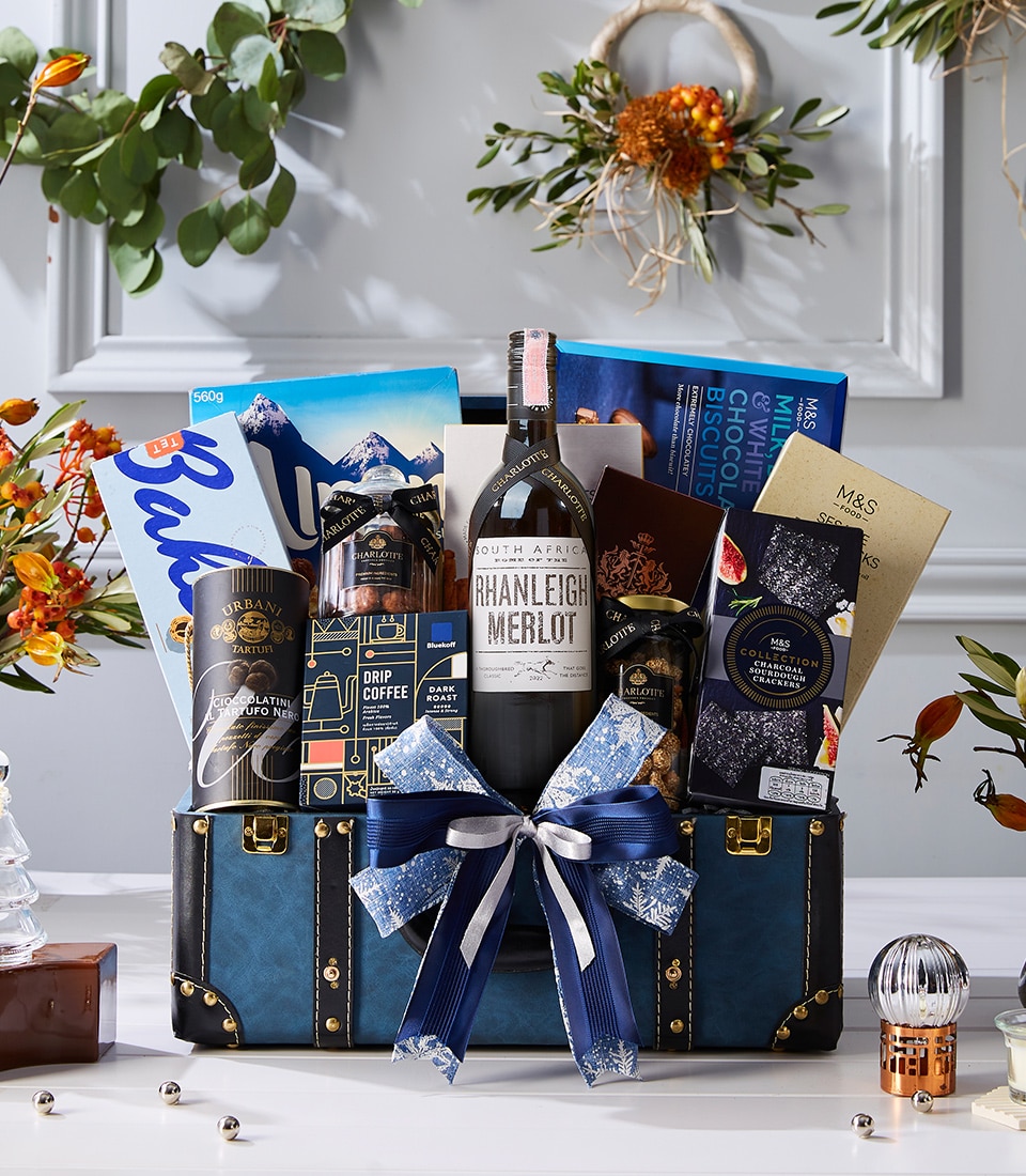 Luxury blue chest hamper with South African Merlot red wine, premium biscuits, drip coffee, chocolates, truffle snacks, and festive bow