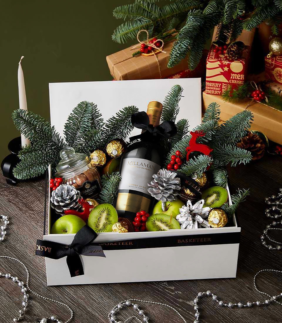 Millaman red wine Christmas gift box with Ferrero Rocher chocolates, fresh kiwi, green apples, and festive pine cones