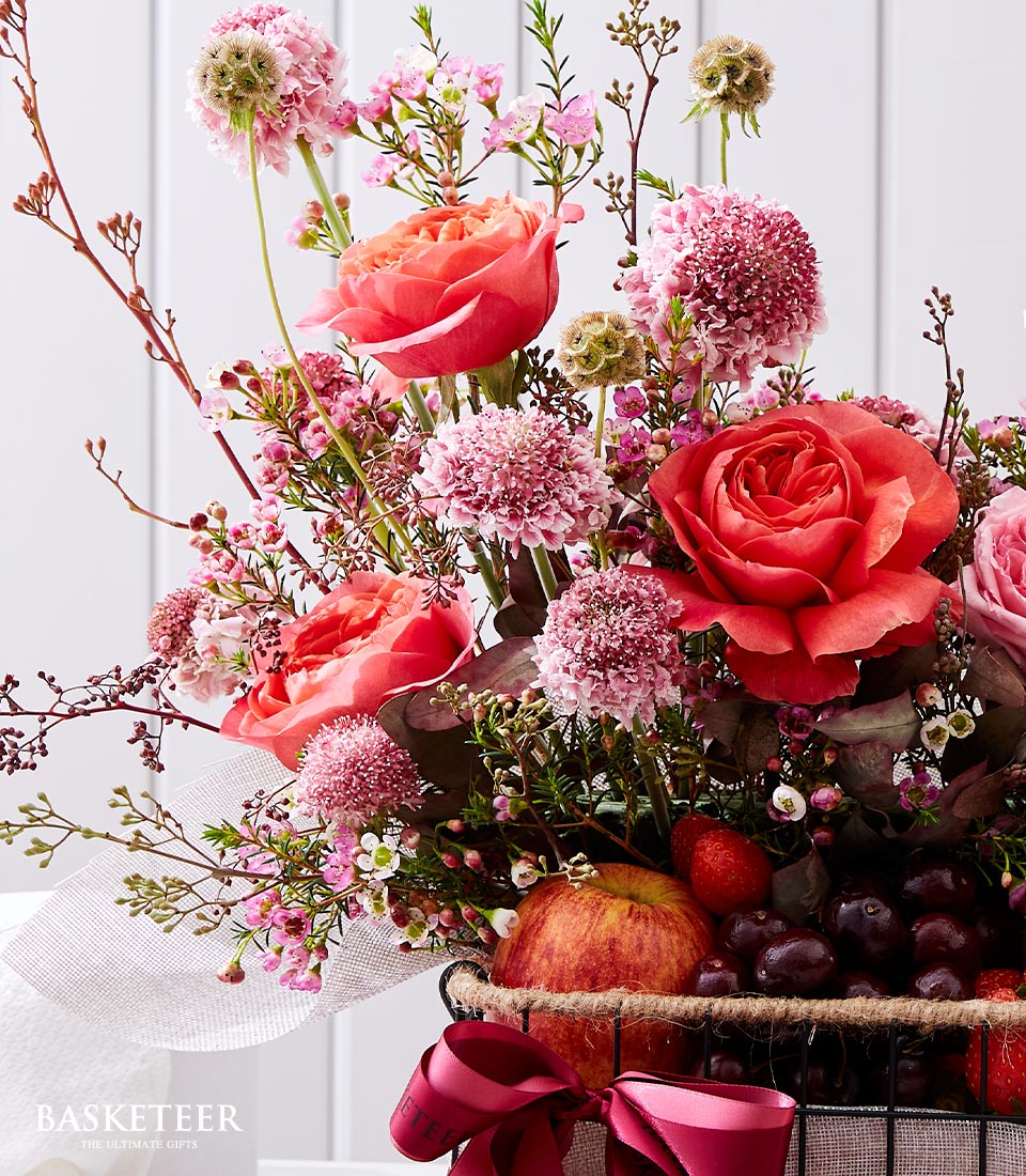 An opulent arrangement showcasing luscious pink roses, charming spherical pink and white blooms, paired elegantly with verdant greenery. This exquisite 
