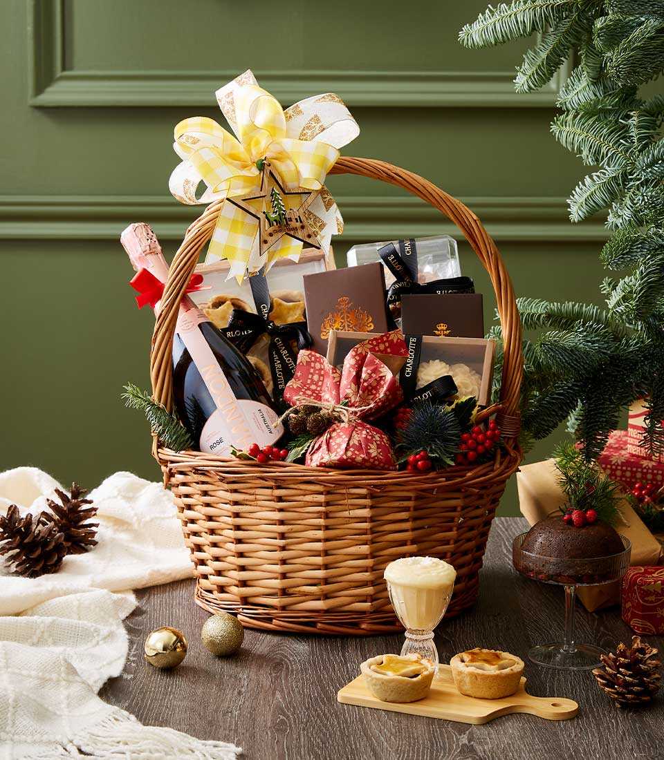 Rustic woven basket with Chandon Rosé sparkling wine, assorted chocolates, cookies, festive treats, and yellow Christmas bow