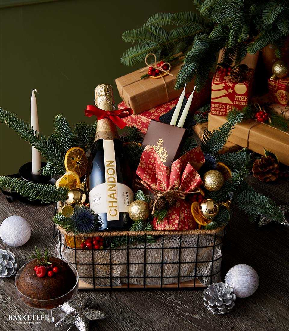 Christmas gift basket with Chandon Brut sparkling wine, dark chocolate bar, pine cones, dried oranges and gold baubles