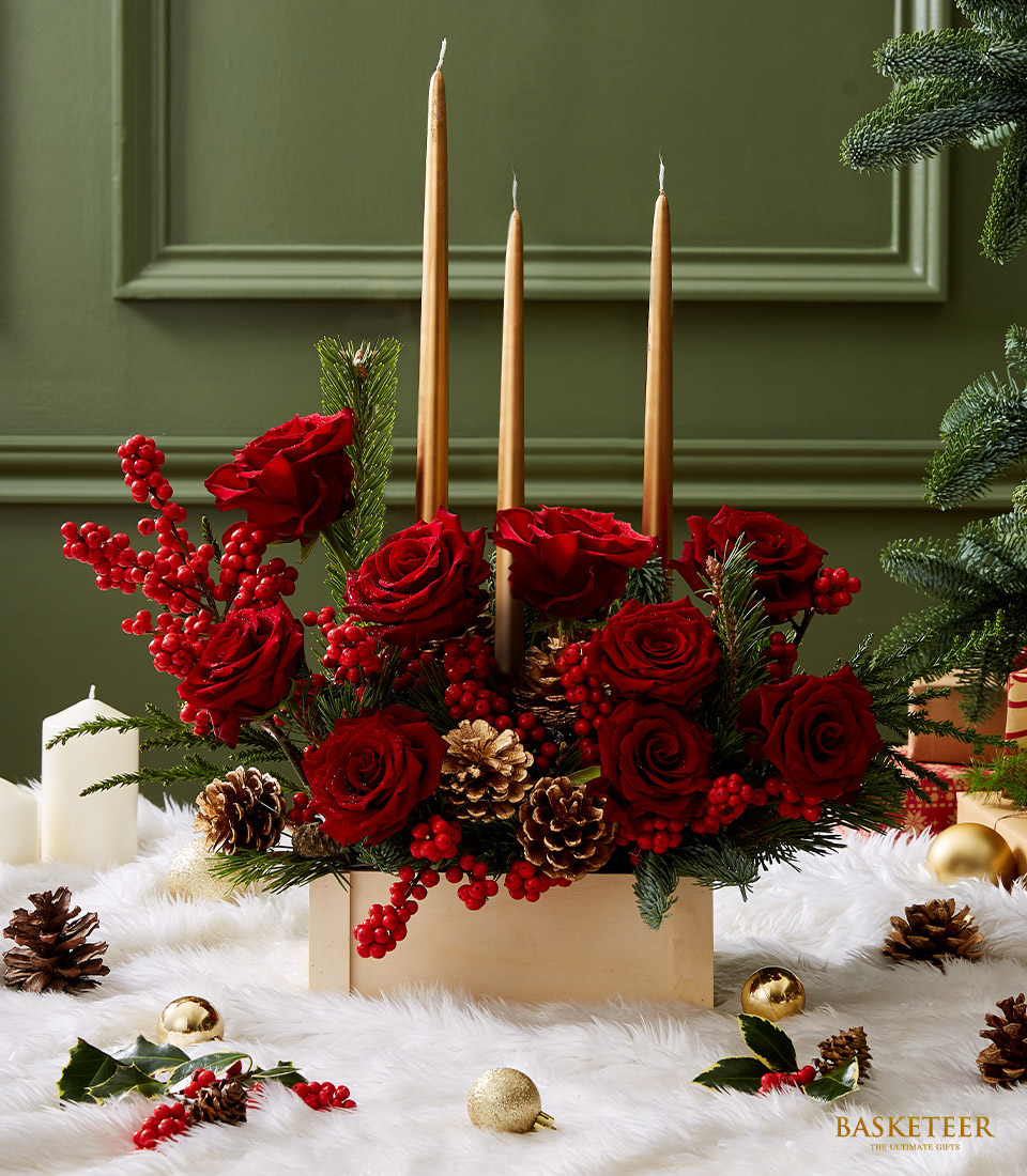 Elegant Christmas centerpiece with red roses, golden candles, pinecones, and festive greenery, perfect for holiday table decor.