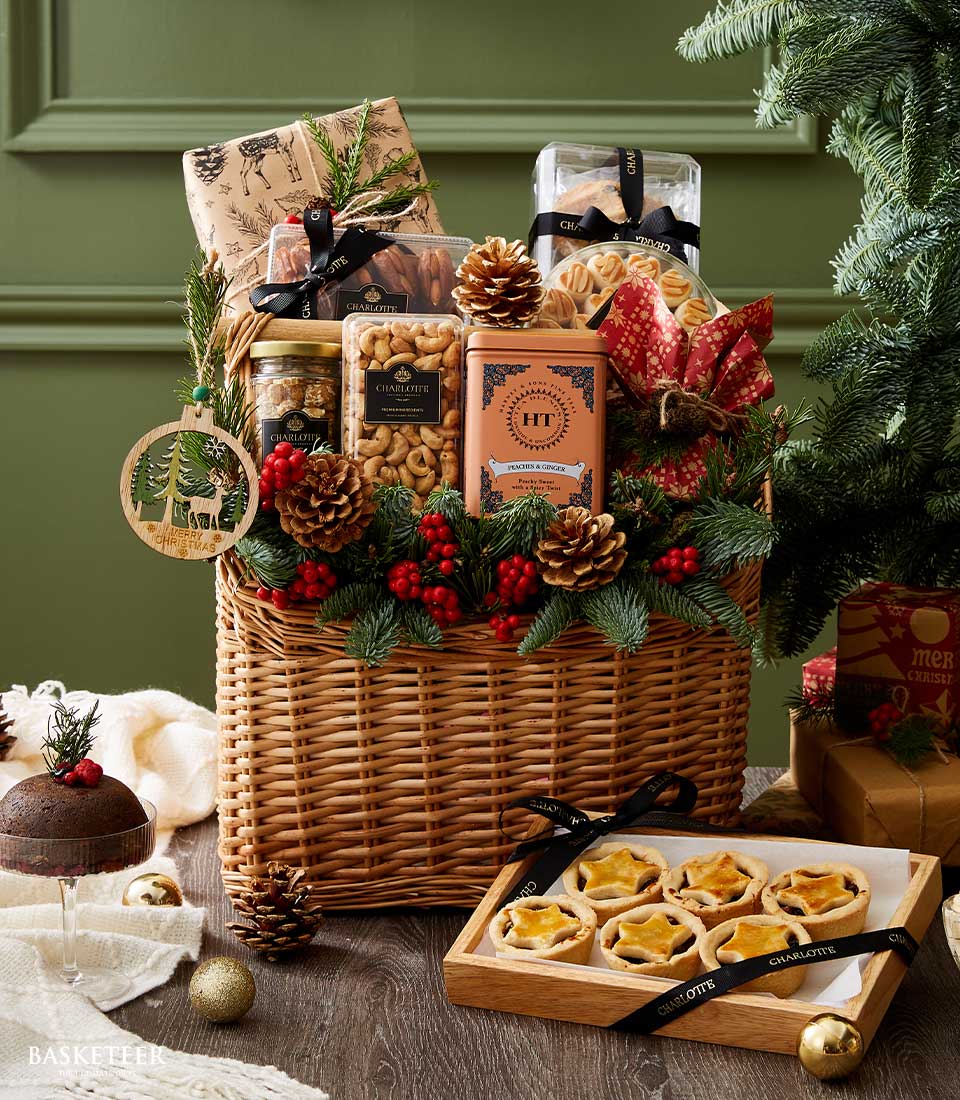 Festive holiday gift basket filled with premium nuts, tea, pastries, and Christmas decor featuring pinecones and red berries.