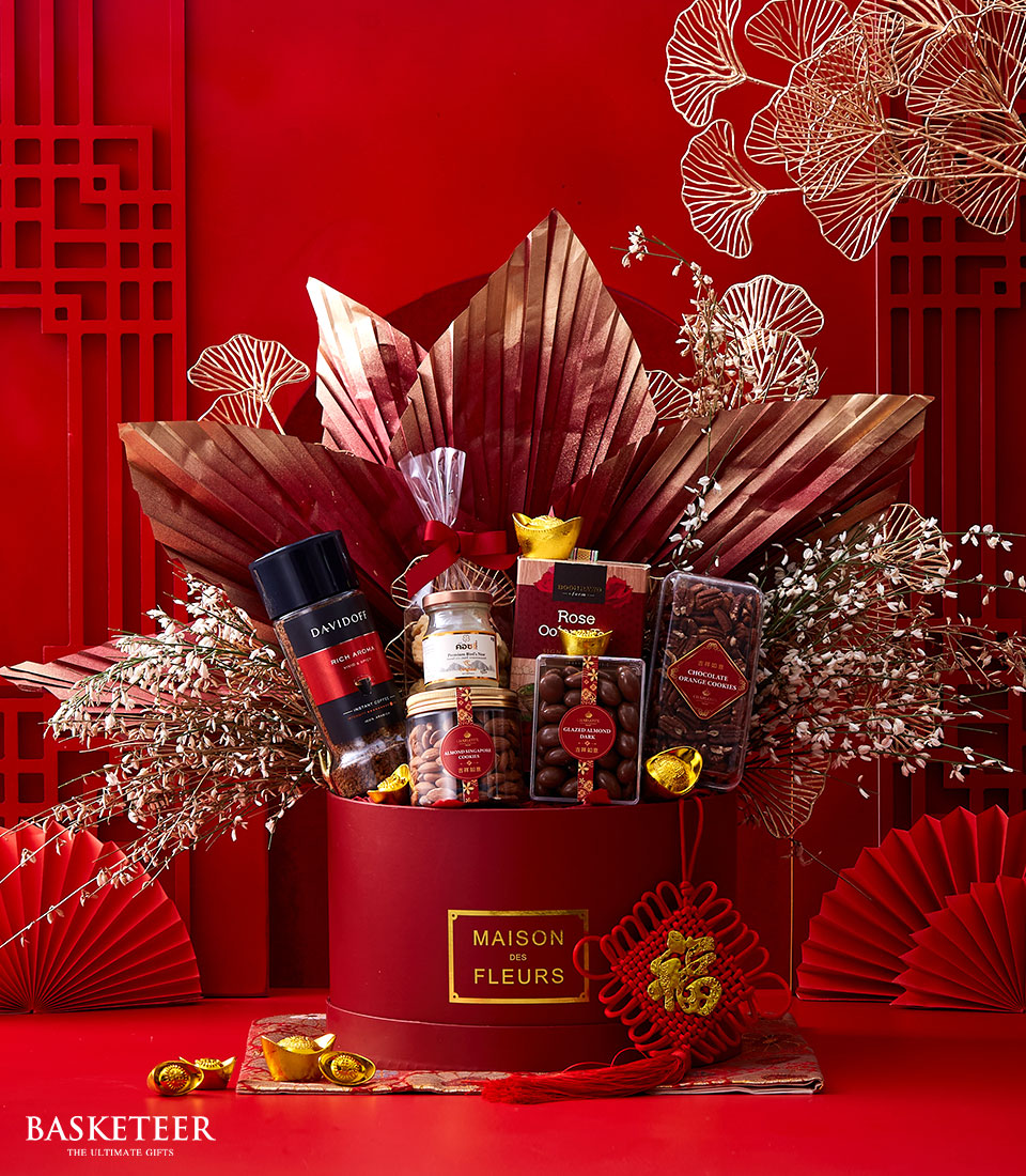 Chinese New Year Gift In Cookies, Chocolate, Tea, Nuts and Bird's Nest With Flowers Decoration In The Red Box.