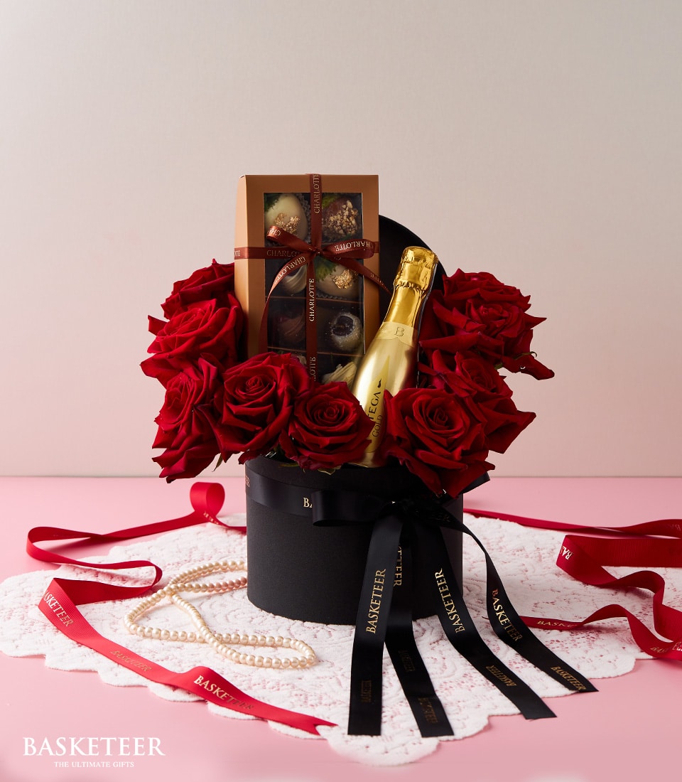 Elegant gift box of red roses, champagne, and chocolate for romantic occasions