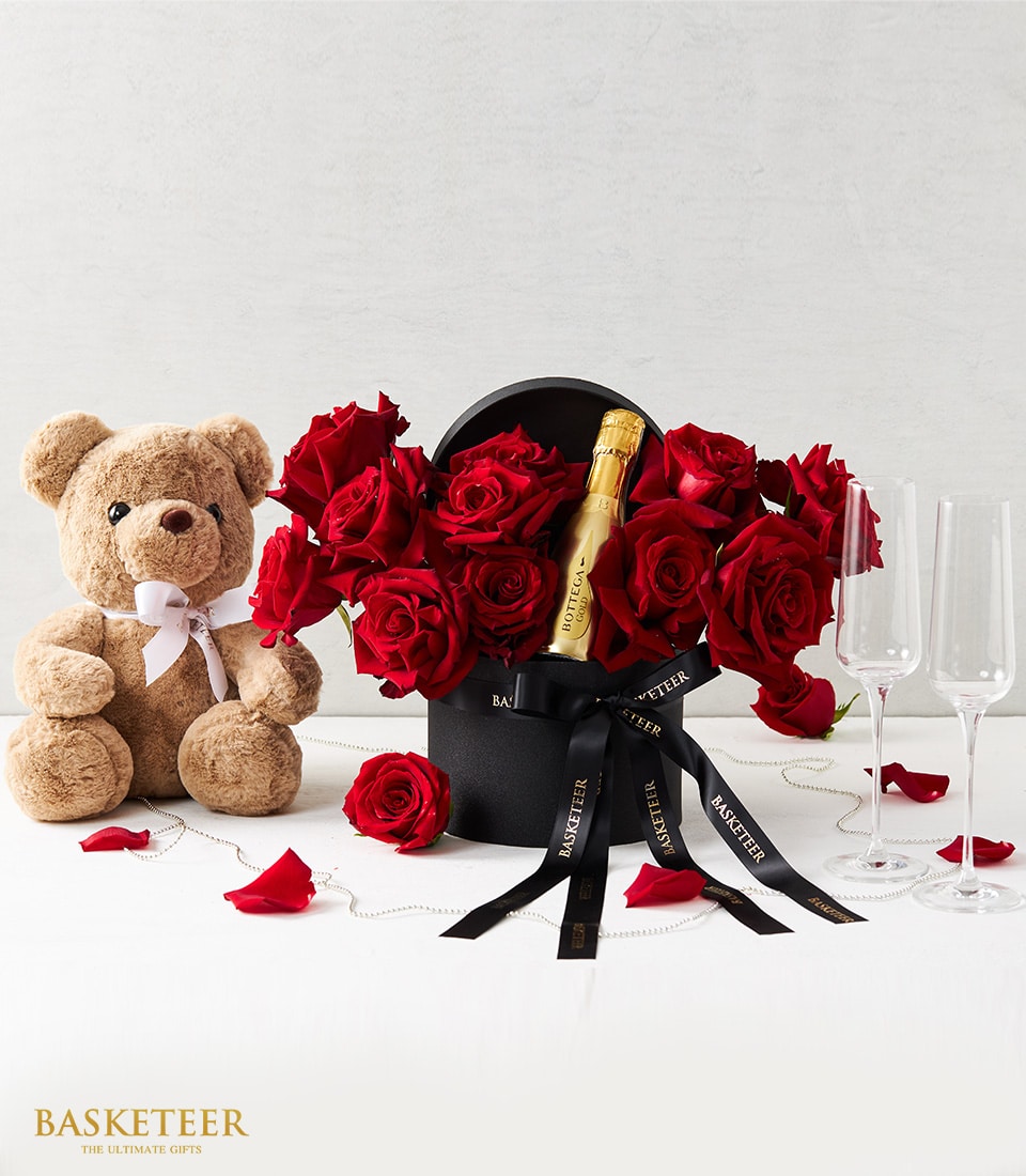 Romantic gift set with Bottega Gold mini bottle, red roses, teddy bear, and champagne flutes
