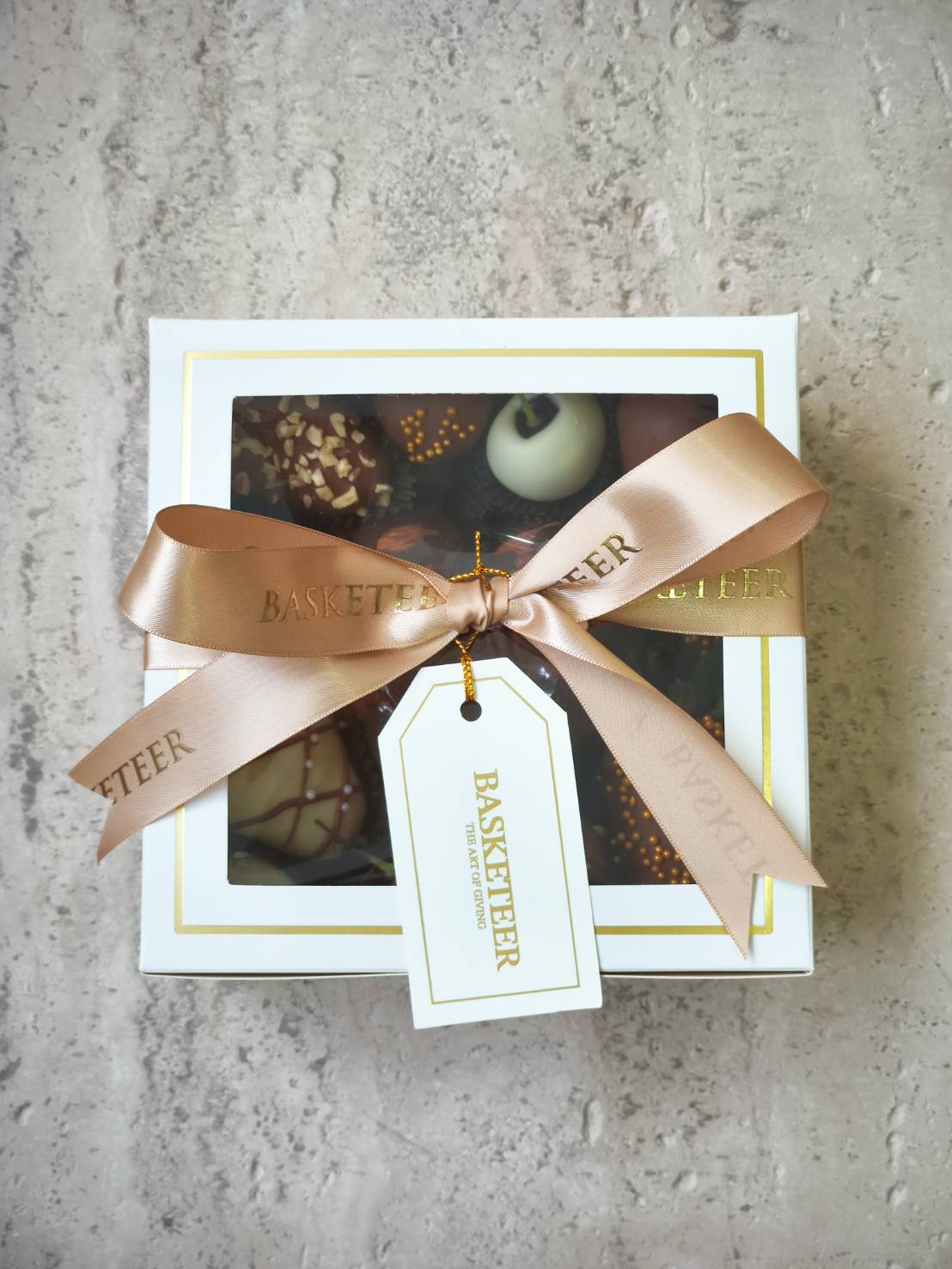 Luxury assorted chocolate gift box with premium truffles, decorated with golden brown satin ribbon – elegant gift for special occasions