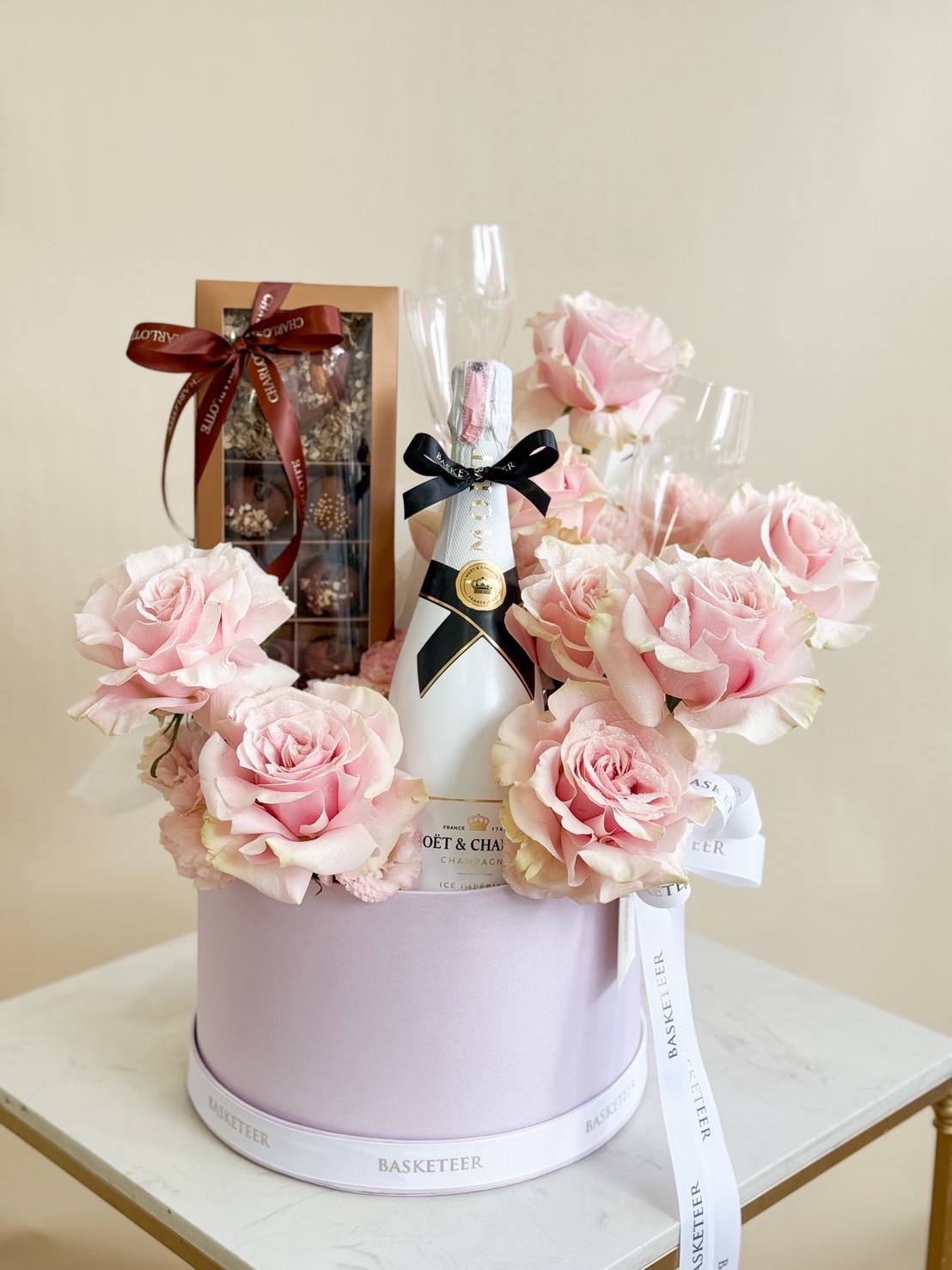 Luxury celebration box with Moët & Chandon champagne, pink roses, chocolates, and crystal flutes