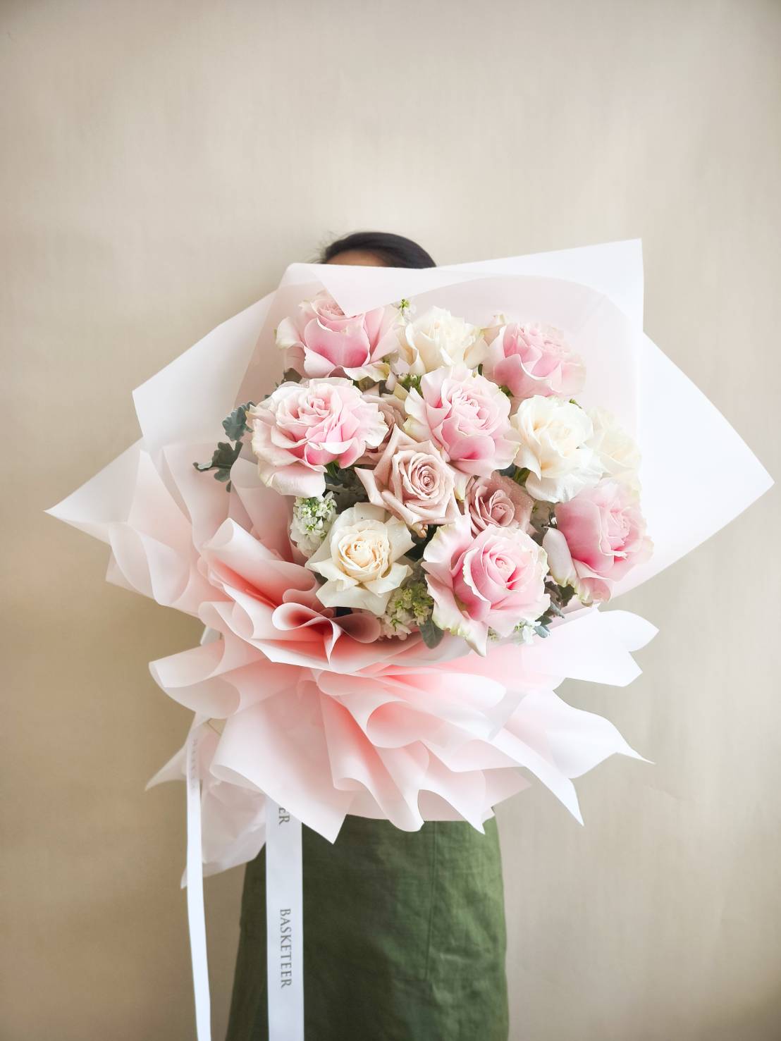 Large bouquet of fresh pink and white roses, wrapped in soft pink and white paper with satin ribbons.
