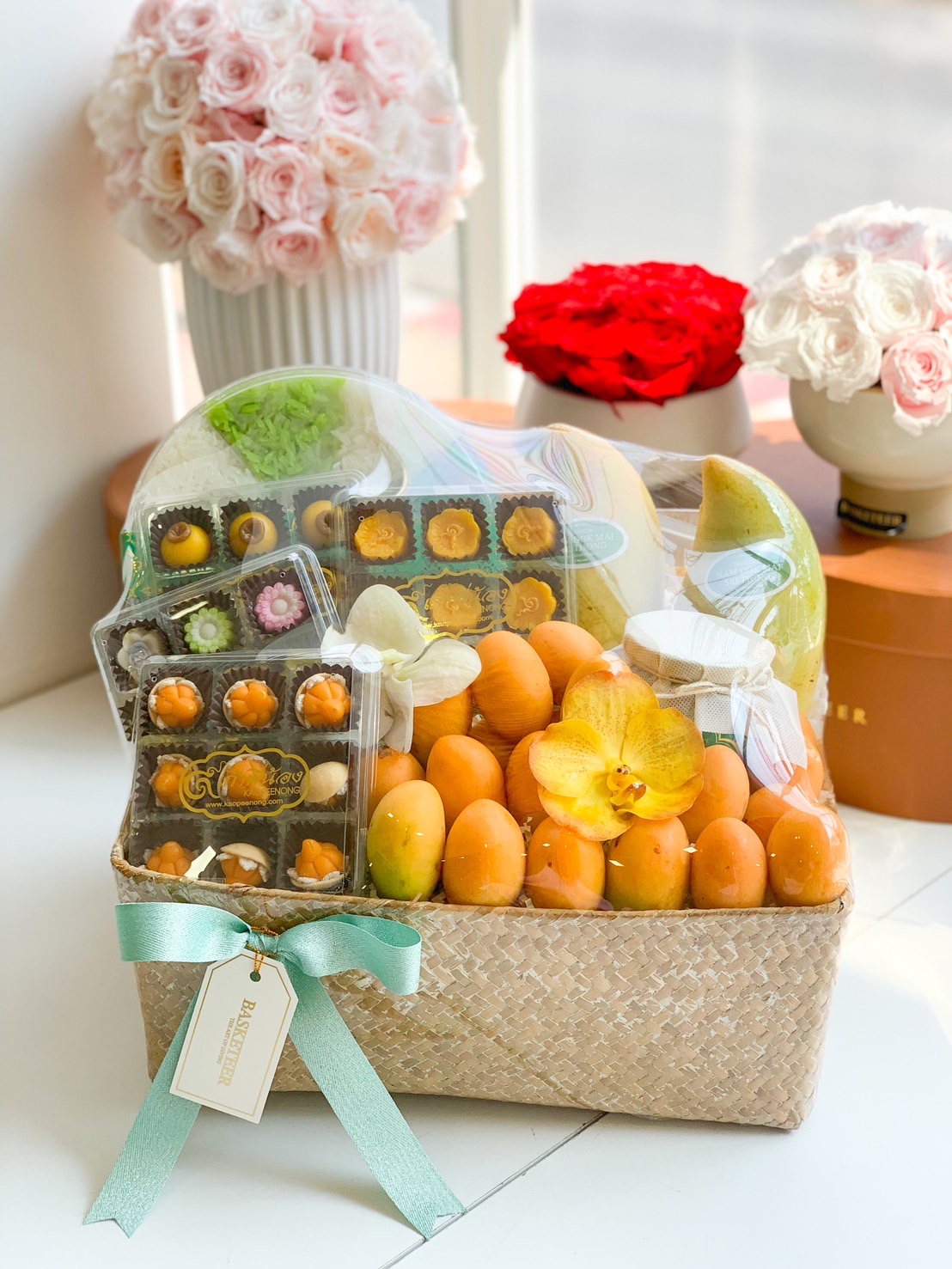 Premium fruit basket with Nam Dok Mai mangoes, Mayongchids, and royal Thai desserts, adorned with orchids
