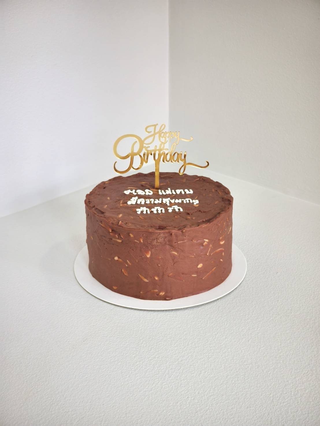 Round chocolate almond cake with gold 