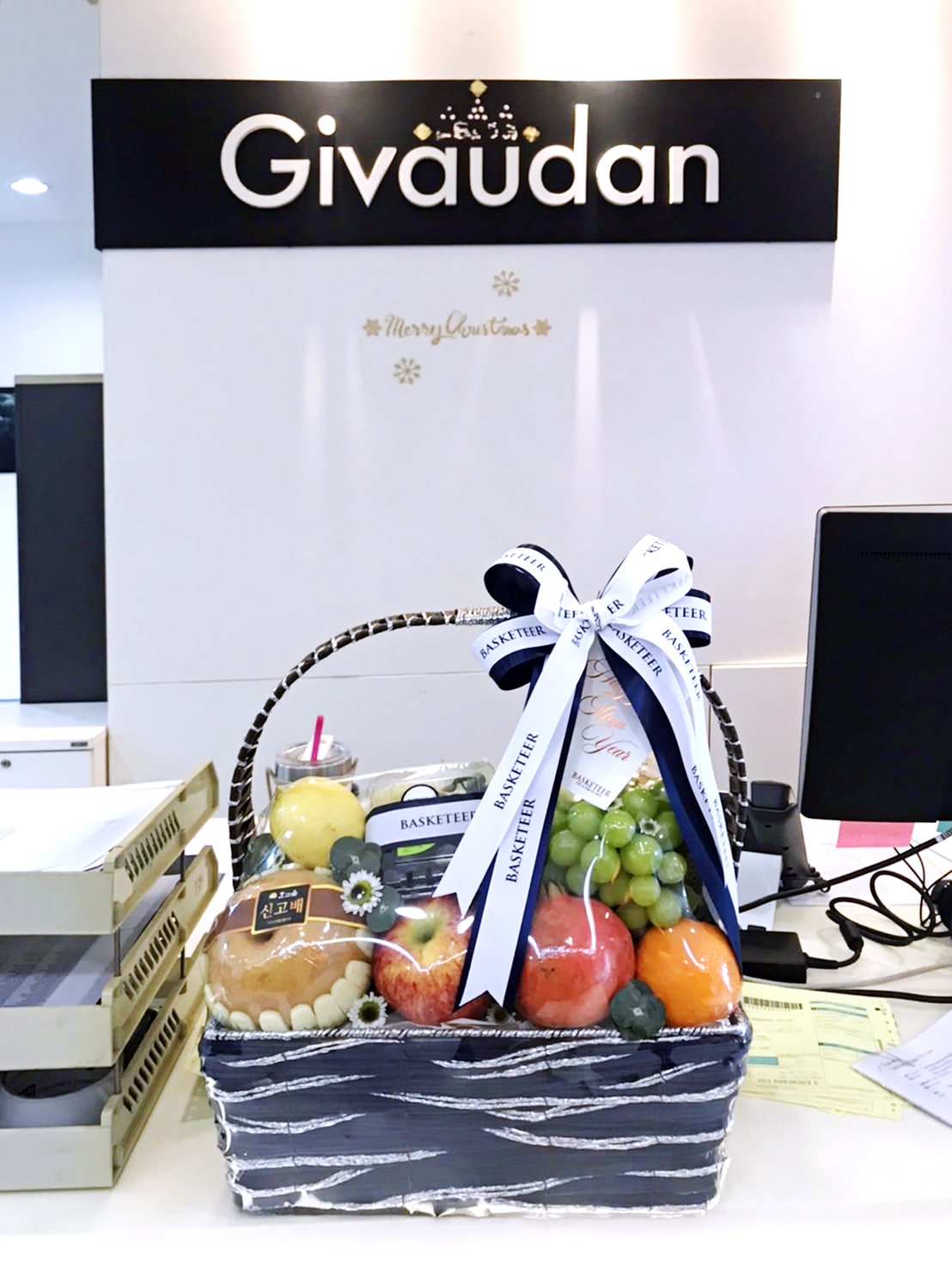 A Fresh Fruit Symphony Basket with assorted fruits and a ribbon labeled 