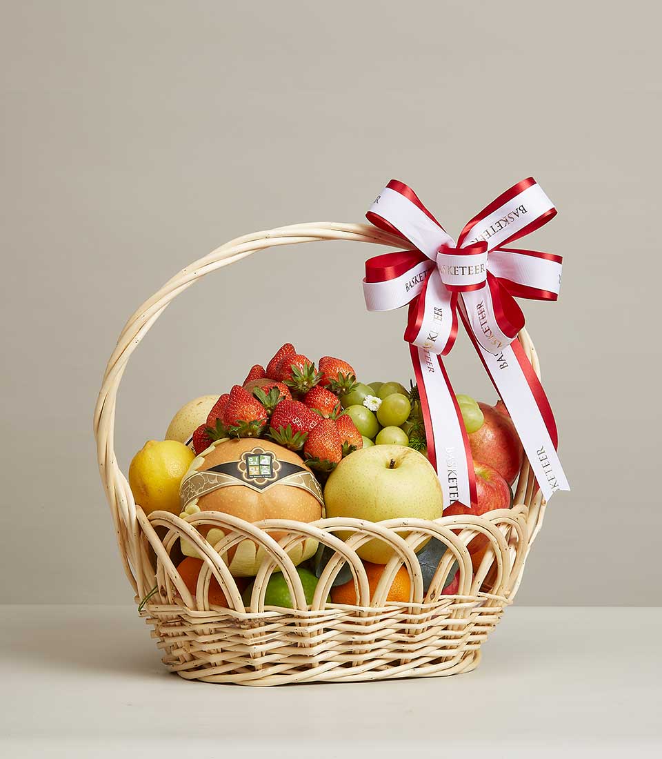 Natural colored rattan gift basket Filled with a variety of fresh fruits such as red strawberries. Yellow Chinese Pear and many others It is decorated with a red and white ribbon bow with 