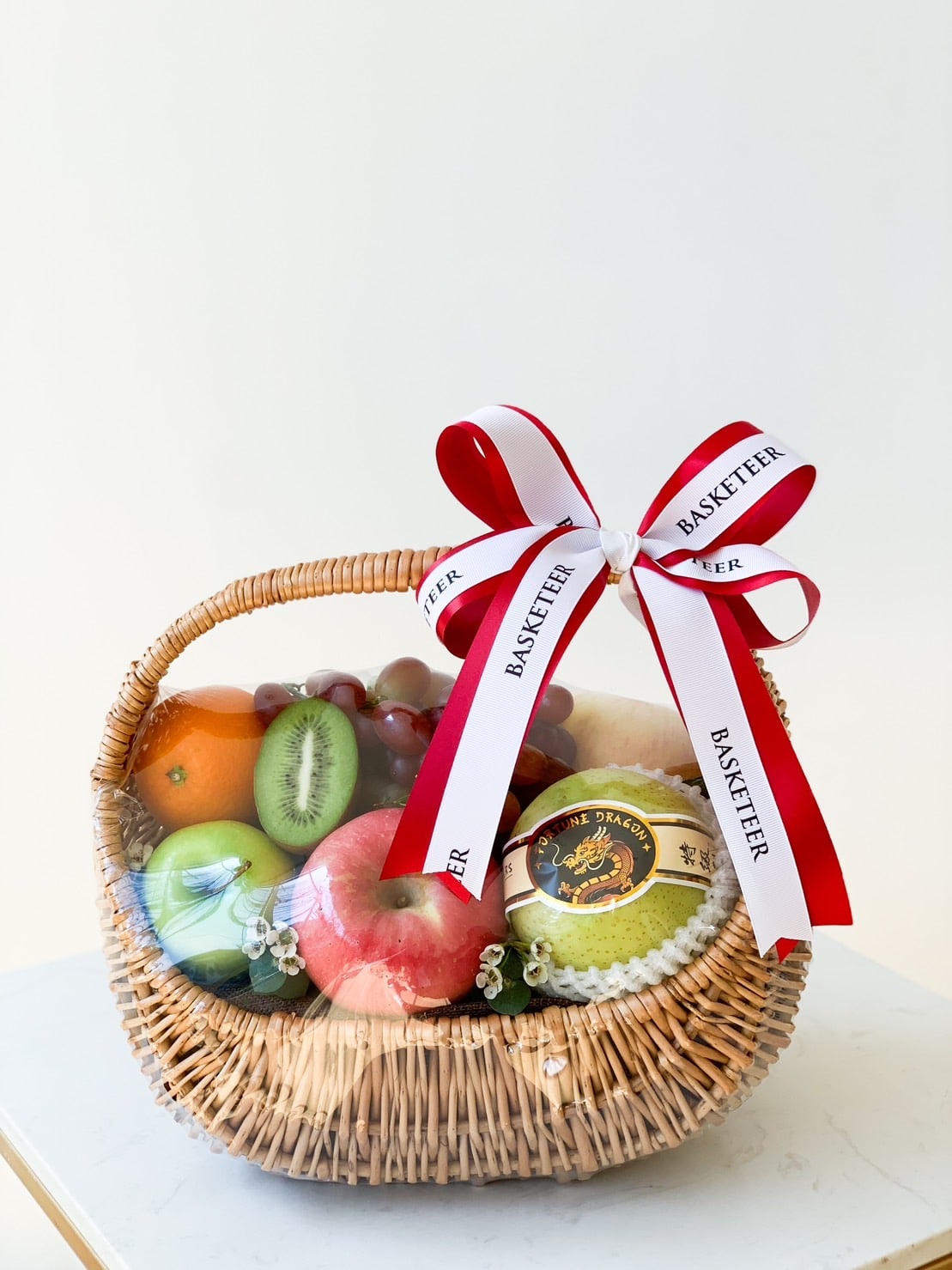 A wicker gift basket with a red and white 