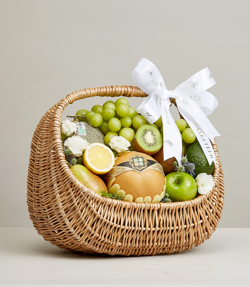 Assortment of Mixed Fresh Fruits in a Natural Willow Basket With White a Bow