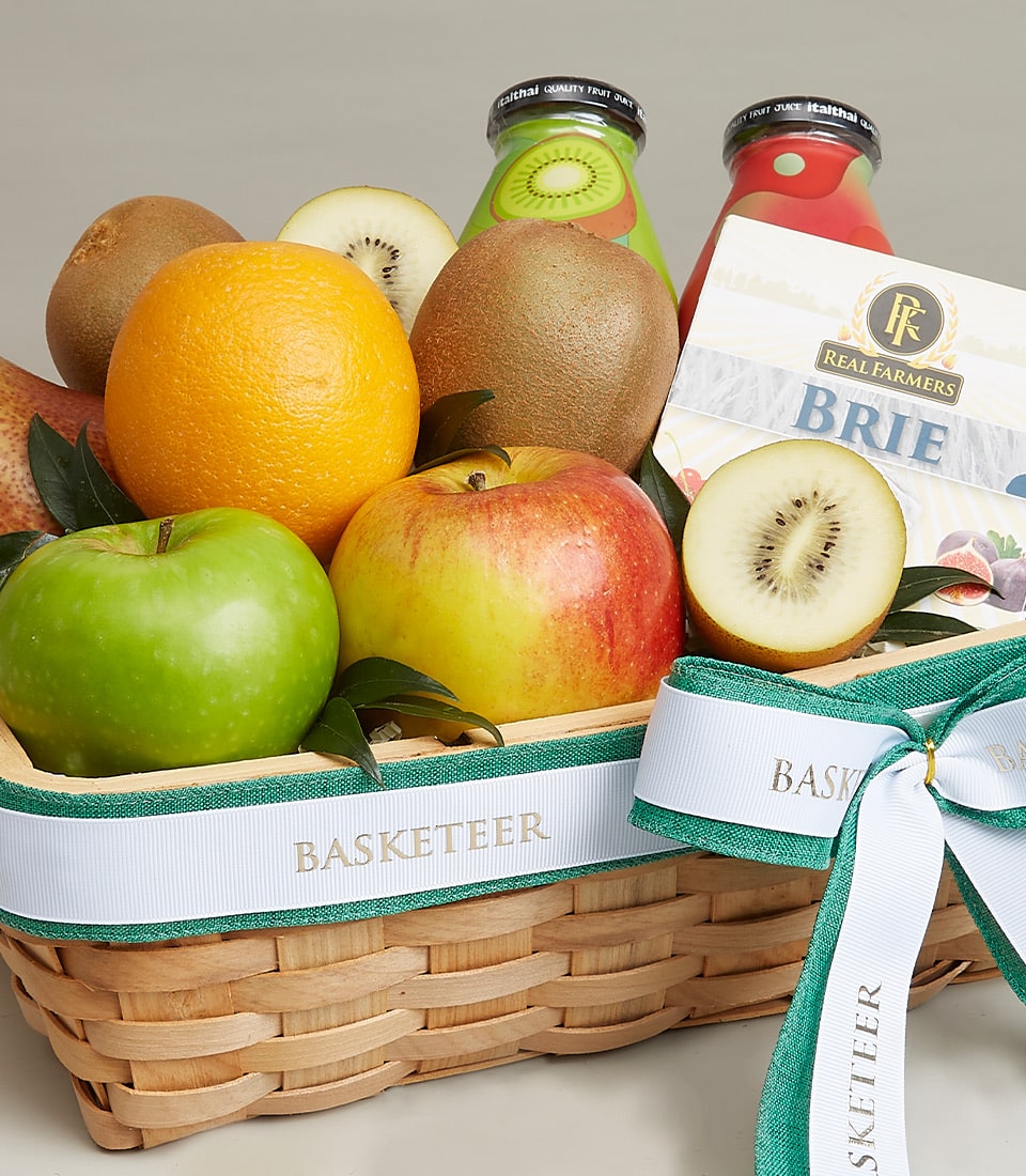 A luxurious wicker basket filled with an exquisite selection of fresh fruits including a crisp green apple, a succulent red apple, a juicy orange, and an enticing kiwi along with its sliced counterpart. This gourmet offering is artfully paired with two bottles of premium fruit juice and a lavish box of creamy Brie cheese. Adorning the ensemble is an elegant white and green ribbon proudly inscribed with the 