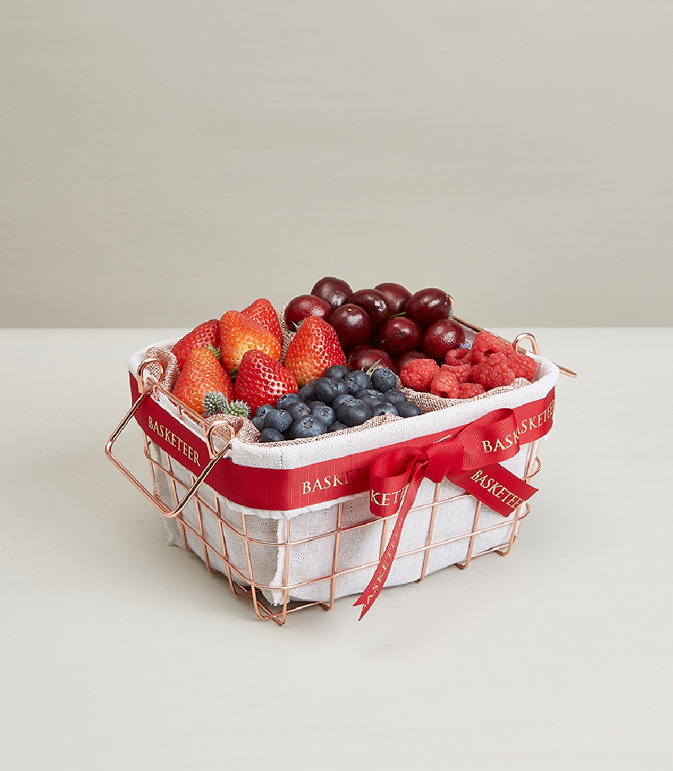 Indulge in our Premium Mixed Berry Basket, featuring a delectable selection of fresh strawberries, blueberries, raspberries, and cherries, totaling four fruits. Presented in an elegant pink gold steel frame basket adorned with a striking red bow decoration, this gift is perfect for any occasion. Order now and treat your loved ones to a burst of fruity delight!