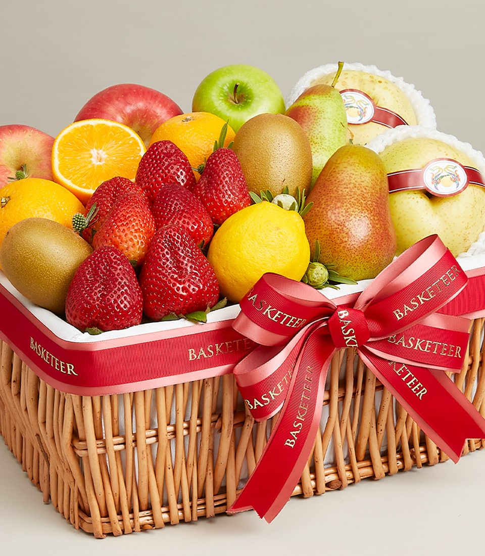 An exquisite wicker basket overflowing with a vibrant assortment of the finest strawberries, apples, pears, oranges, lemons, kiwis, and melons. This luxurious fruit collection is elegantly adorned with a sophisticated red ribbon featuring the distinguished 